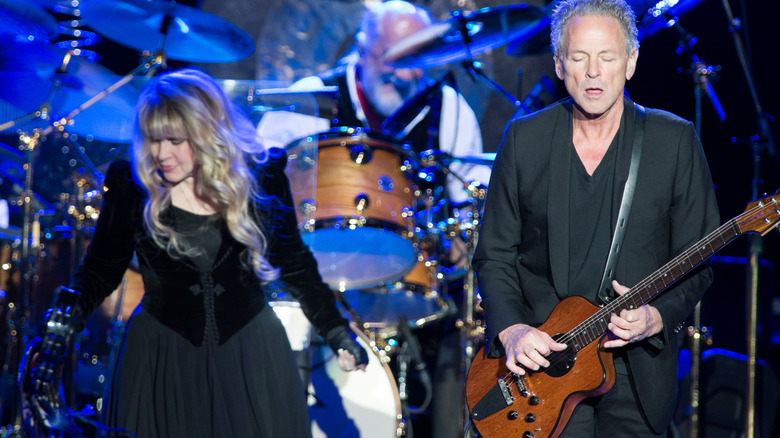 stevie nicks dancing on stage while lindsay buckingham plays guitar