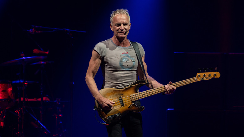 Sting playing guitar on stage