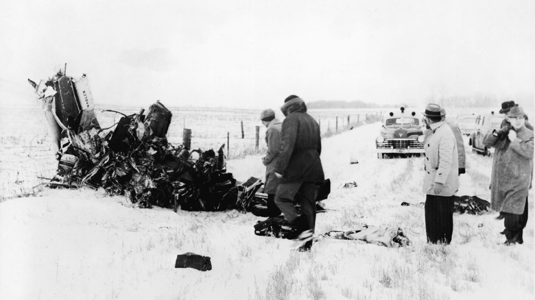 People observing the wreckage of the plane carrying Buddy Holly, Ritchie Valens, and The Big Bopper