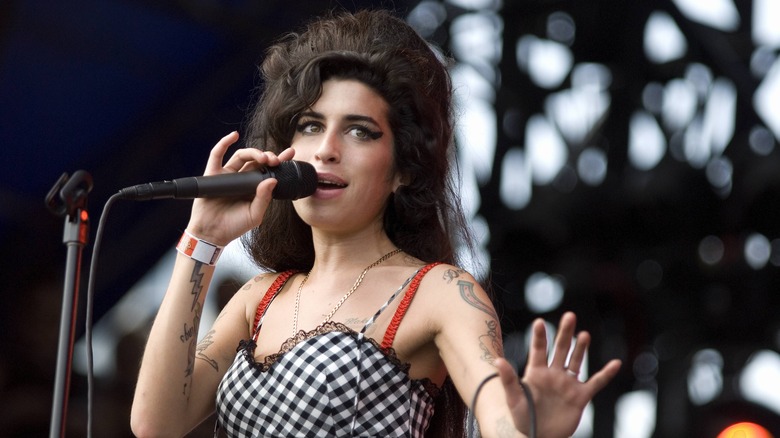 Amy Winehouse polkadot dress sings into microphone