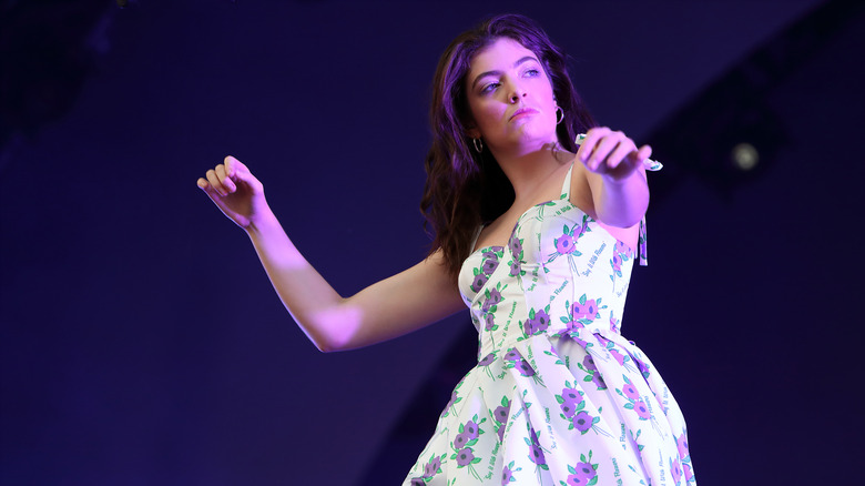 Lorde arms outstretched on stage