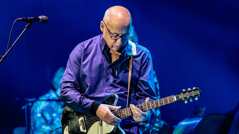 Mark Knopfler plays guitar bald glasses