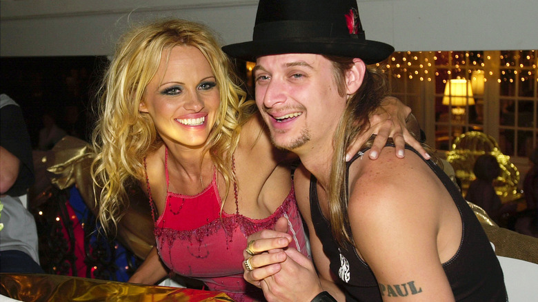 Kid Rock and Pamela Anderson smiling at a table at an event