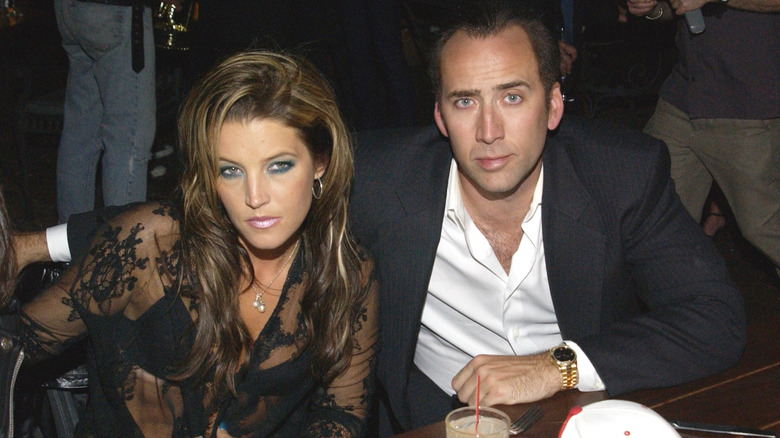 Lisa Marie Presley and Nicolas Cage seated at a table during an event