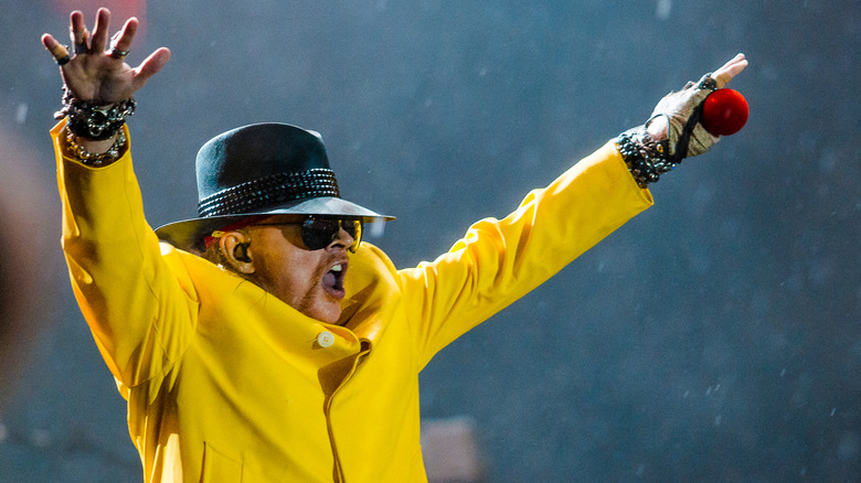 Axl Rose wearing a yellow jacket during a 2011 performance in Rio de Janeiro