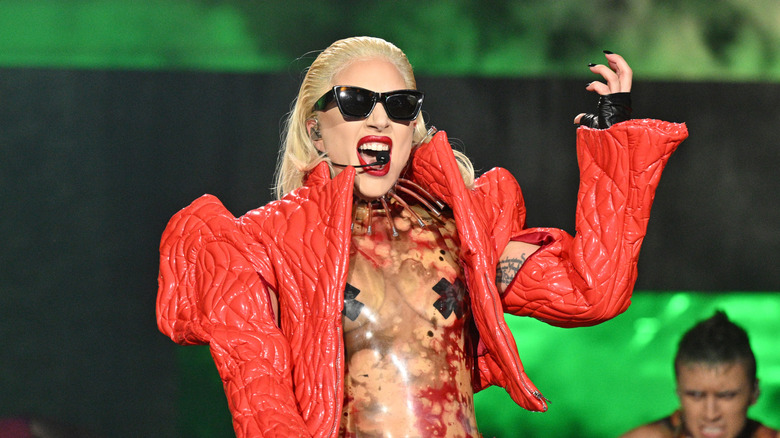 Lady Gaga wearing black sunglasses while performing onstage