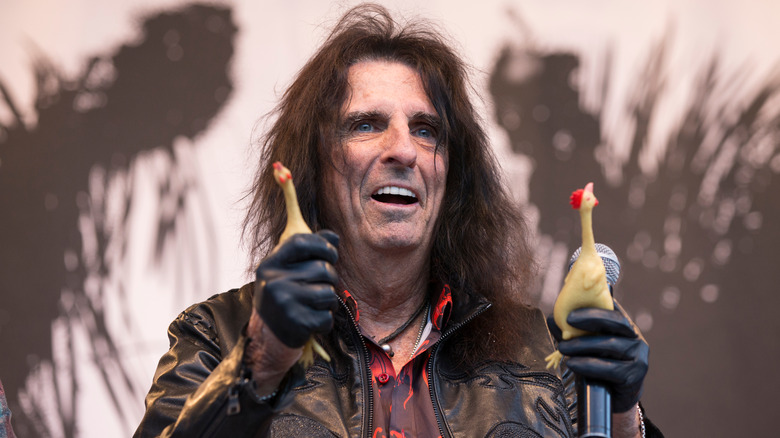 Alice Cooper holding two plastic chickens