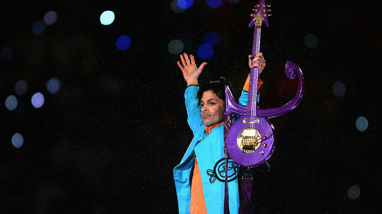 Prince holding up purple guitar