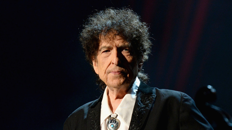 Bob Dylan in dark suit standing on stage