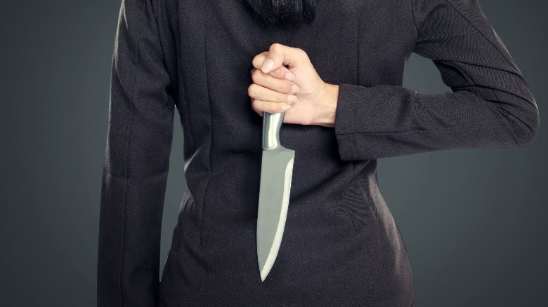 woman with knife behind her back