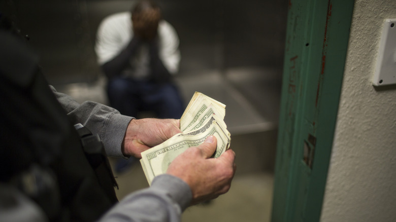 Police officer counting money taken from gang member