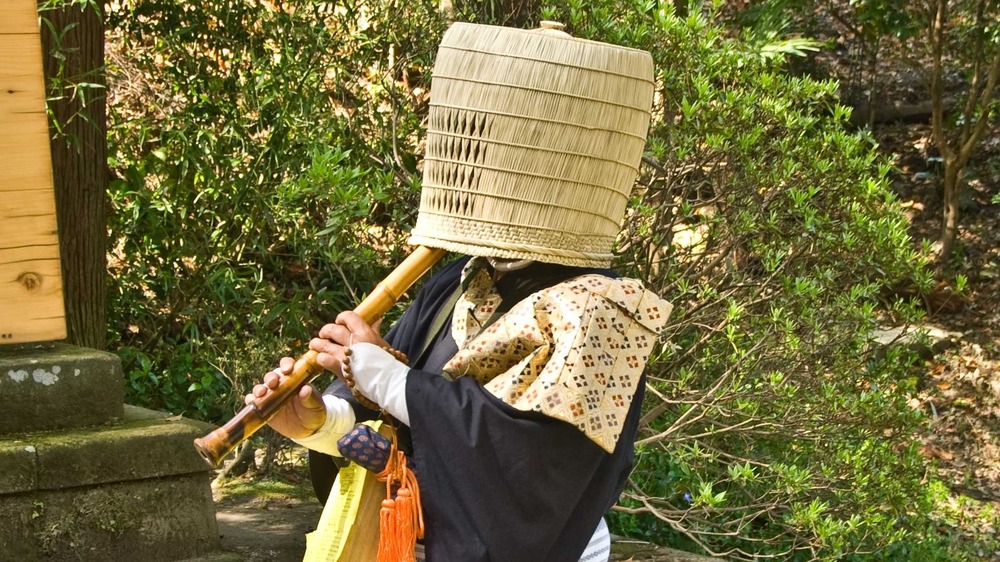 buddhist monk disguised as ninja, wearing basket on head