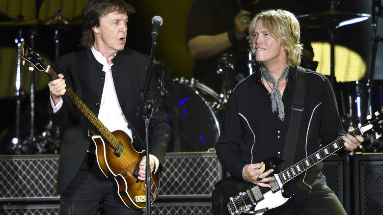 Paul McCartney Brian Ray performing on stage