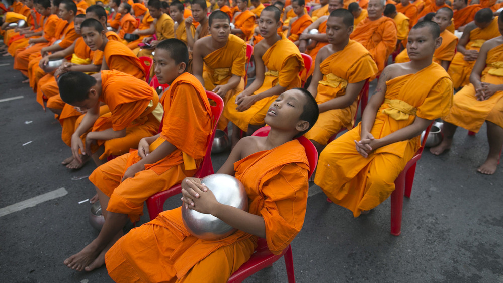 buddhist boy sleeping in a chair