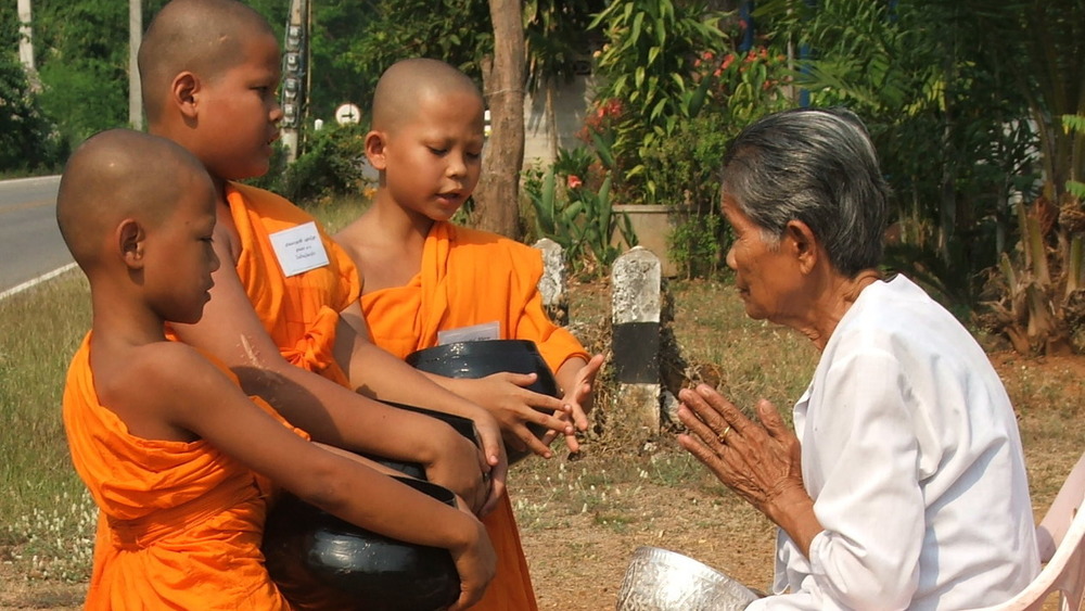 young monks blessing a woman