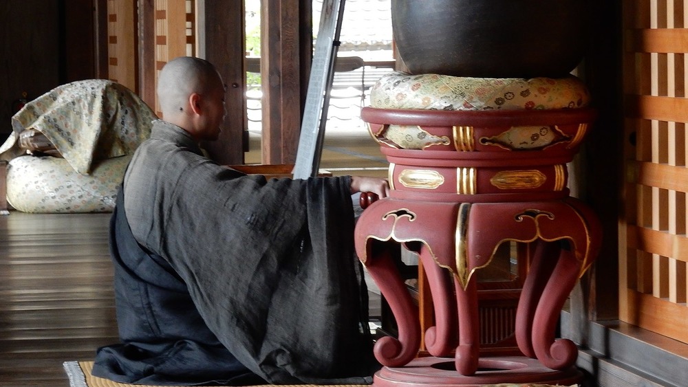 buddhist monk kneeling in temple