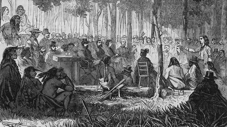 Comanche and white men discuss under trees