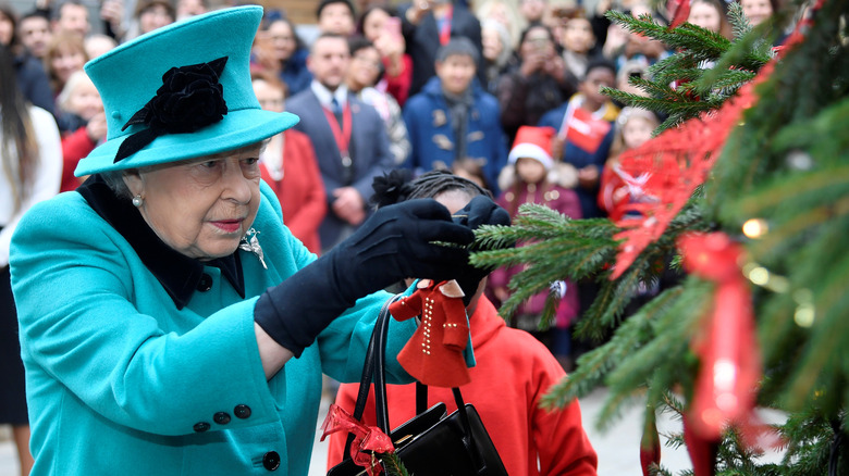 Queen Elizabeth hanging Christmas decoration