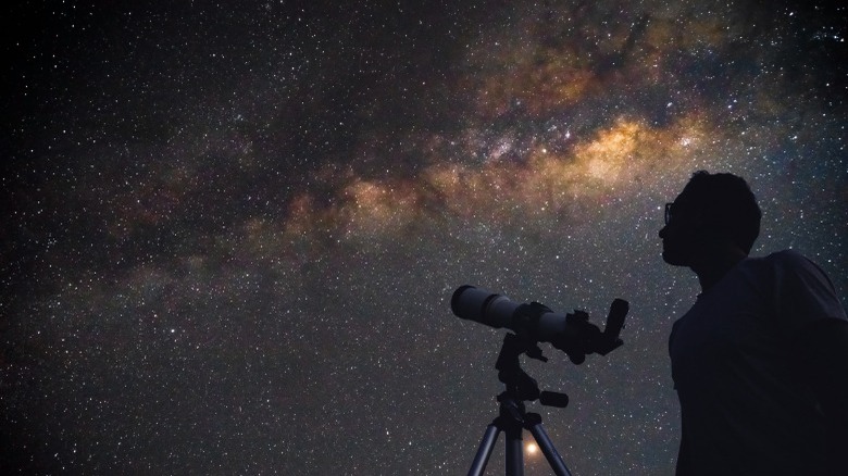 man with telescope starry background