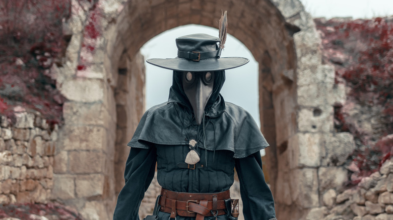 a costumed performer in plague mask