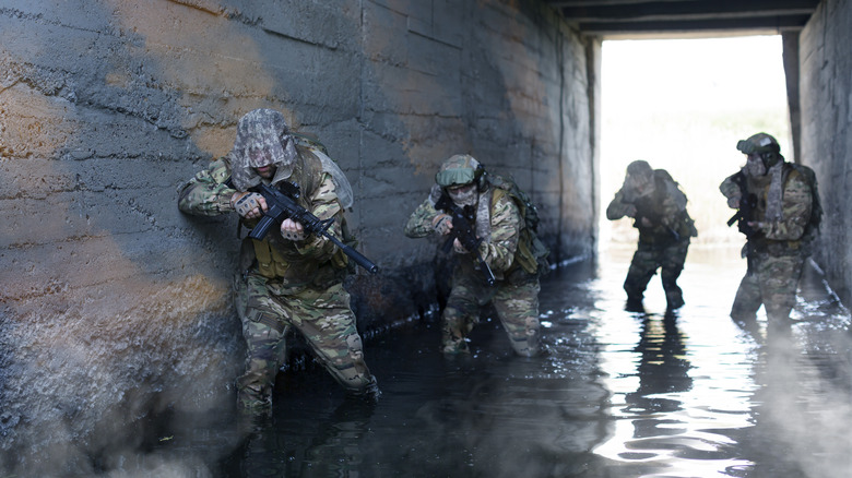 Soldiers underpass walk through water