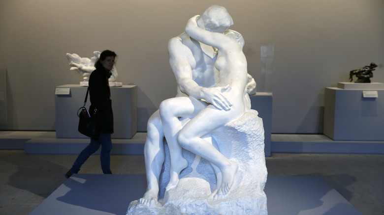 A visitor looks at the sculpture "The Kiss, 1881-1882"