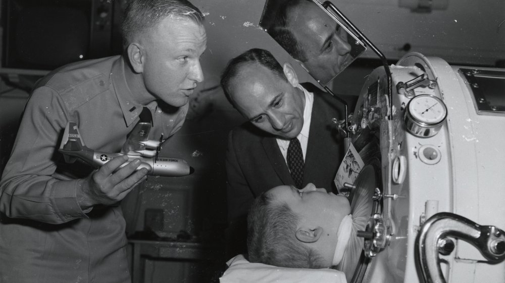  A member of the U.S. Air Force and an unidentified man entertain a child in a ventilator 