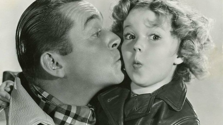 James Dunn giving a kiss on Shirley Temple's cheek, promotional shot