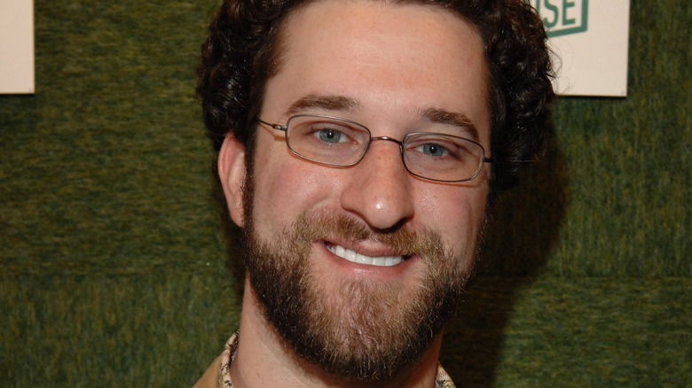 dustin diamond glasses beard green wall