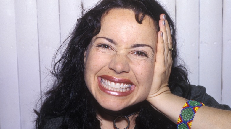 janeane garofalo smiling big hand on face