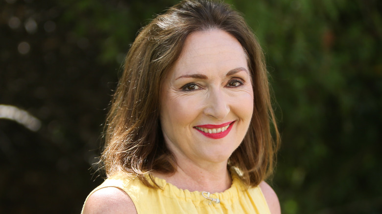 nora dunn grinning yellow dress turned head