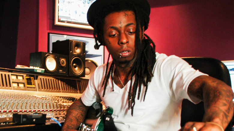 Lil Wayne tuning his guitar in the studio