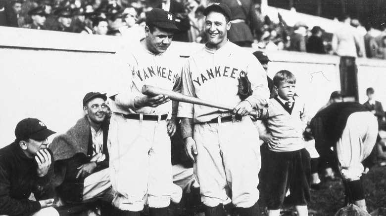 Babe Ruth looking at Lou Gehrig's bat c.1925