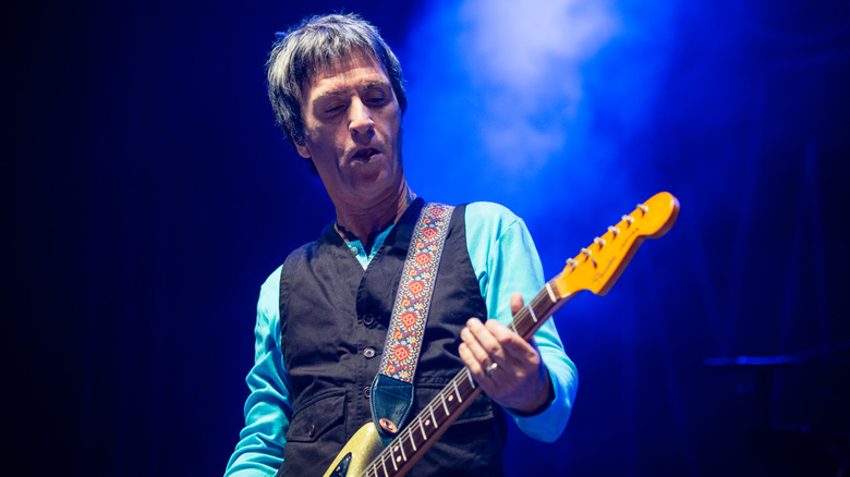 Johnny Marr playing guitar blue backlight