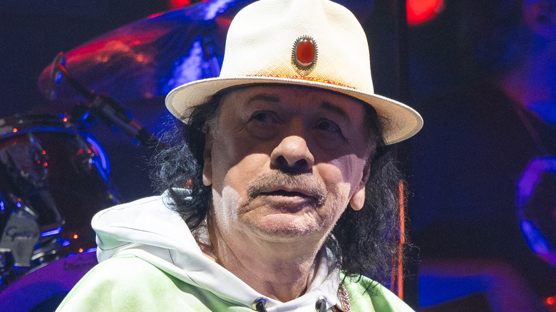 carlos santana wearing white hat onstage