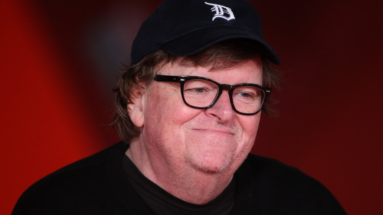 michael moore black cap glasses smiling