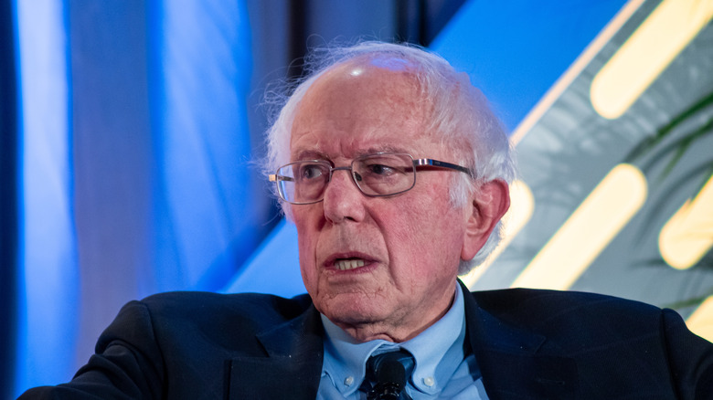 Bernie Sanders suit glasses talking on stage