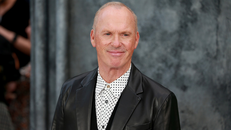 Michael Keaton smiling in a leather jacket