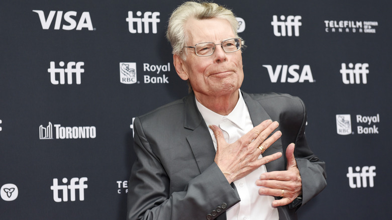 Stephen King with his hand over heart suit at event