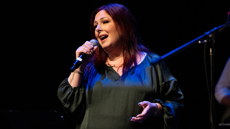 Carnie Wilson singing into a microphone onstage