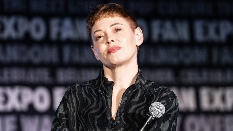 Rose McGowan holding a microphone smiling