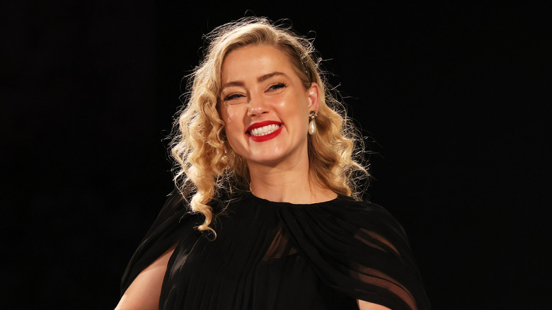 Amber Heard wearing black and smiling