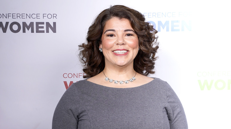 Celeste Headlee wearing a grey dress and smiling for a photo