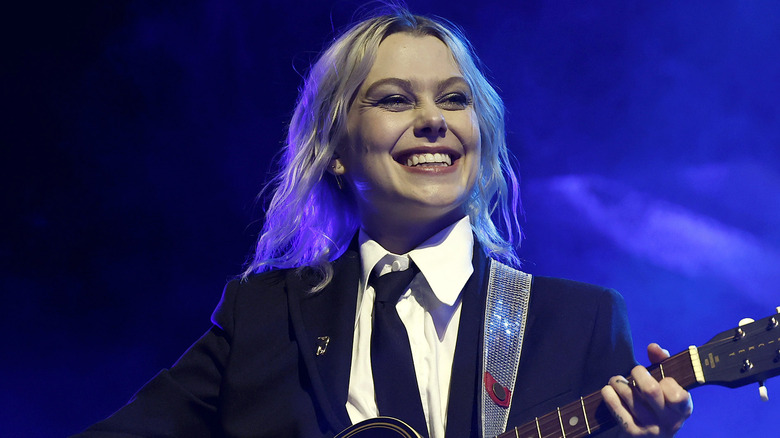 phoebe bridgers smiling playing guitar