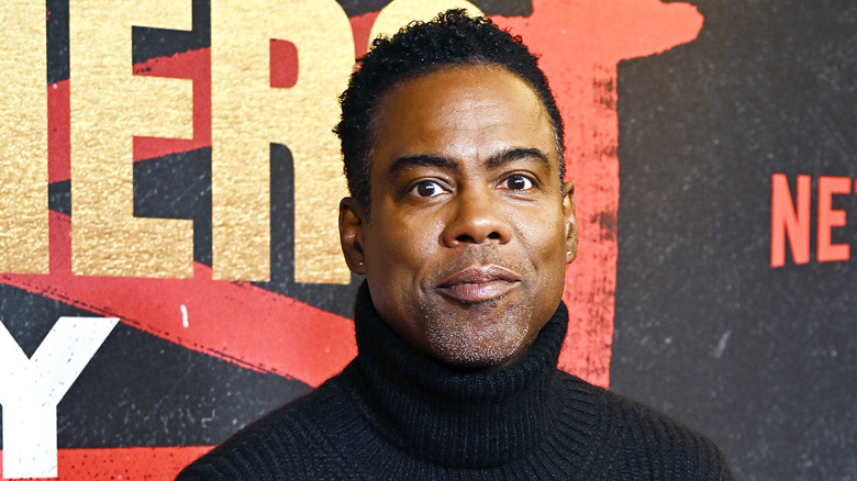 Chris Rock wearing a black turtleneck while posing on the red carpet at 2023 premiere