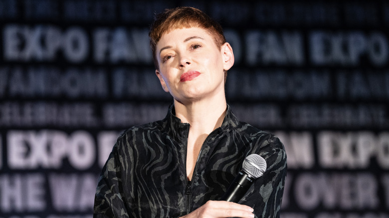 Rose McGowan holding microphone arms crossed