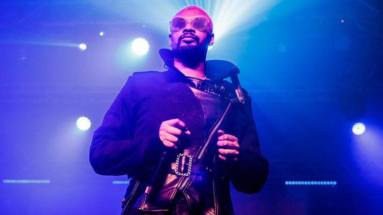 Danny Brown wearing sunglasses and a light show behind him