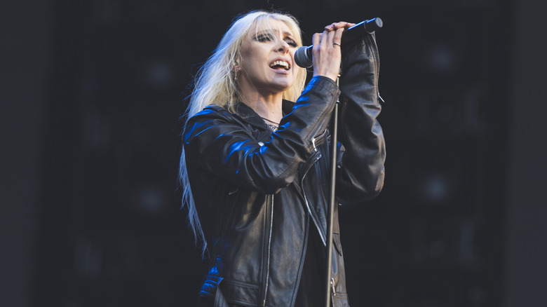 Taylor Momsen wearing a black jacket and singing on stage