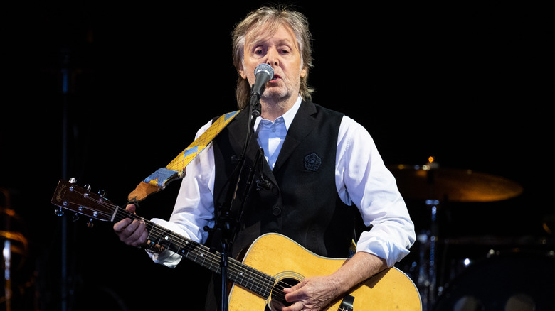 Paul McCartney playing guitar onstage