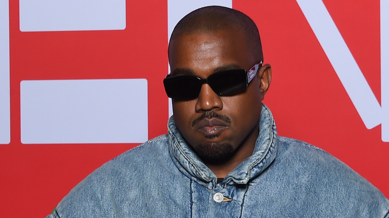 Kanye West sunglasses denim jacket at event